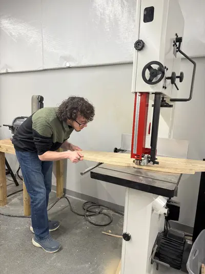 Cutting the slanted wood piece at the bandsaw at school